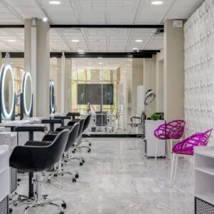 Contemporary salon interior featuring sleek chairs and illuminated vanity mirrors.
